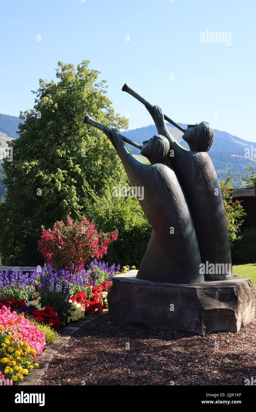 statue avec trompette. profitez de leurs trompettes en été avec ciel bleu et fleurs dans le jardin public. Banque D'Images
