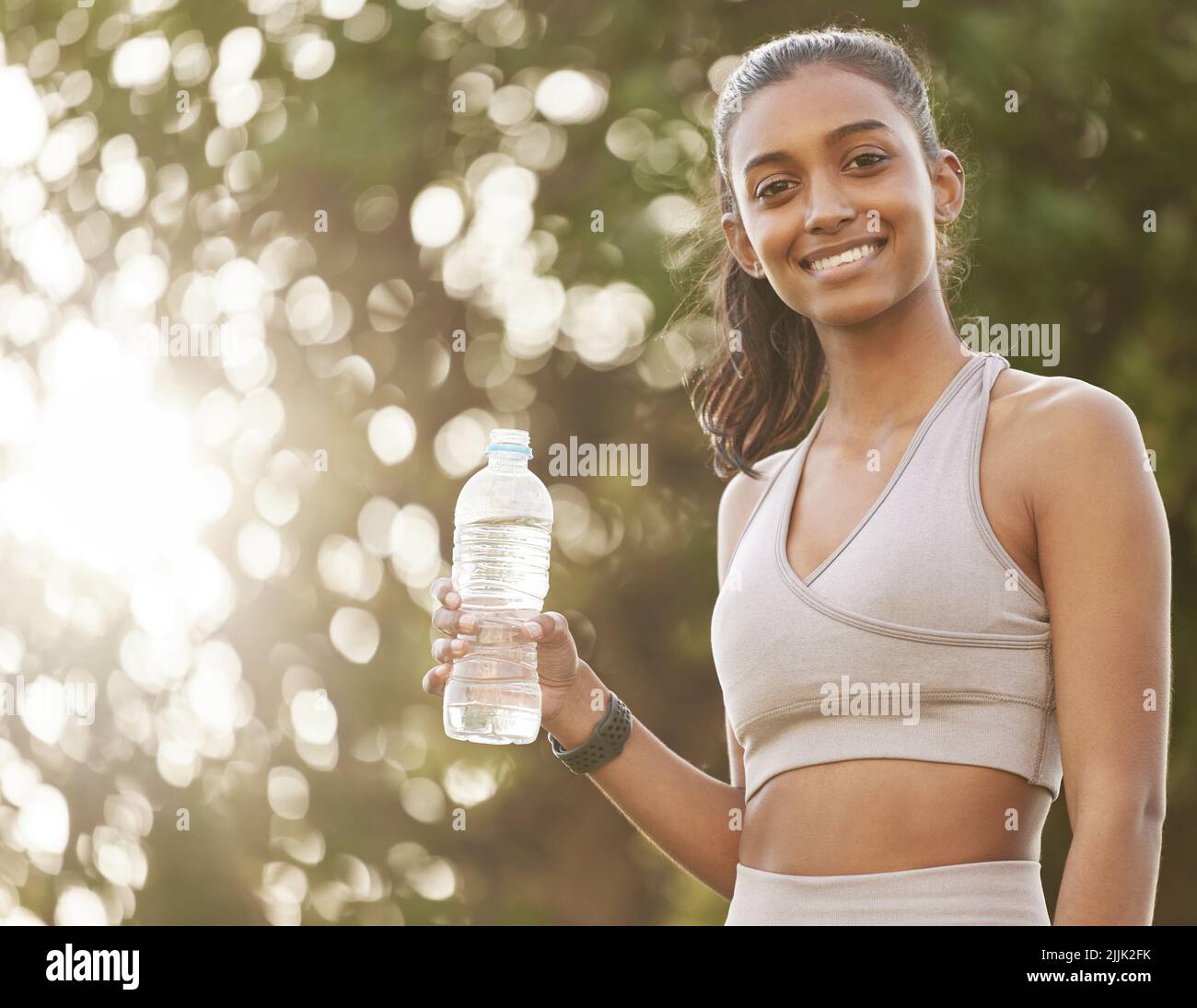 Je viens de refroidir un peu. Portrait d'une jeune femme sportive qui boit de l'eau tout en faisant de l'exercice à l'extérieur. Banque D'Images