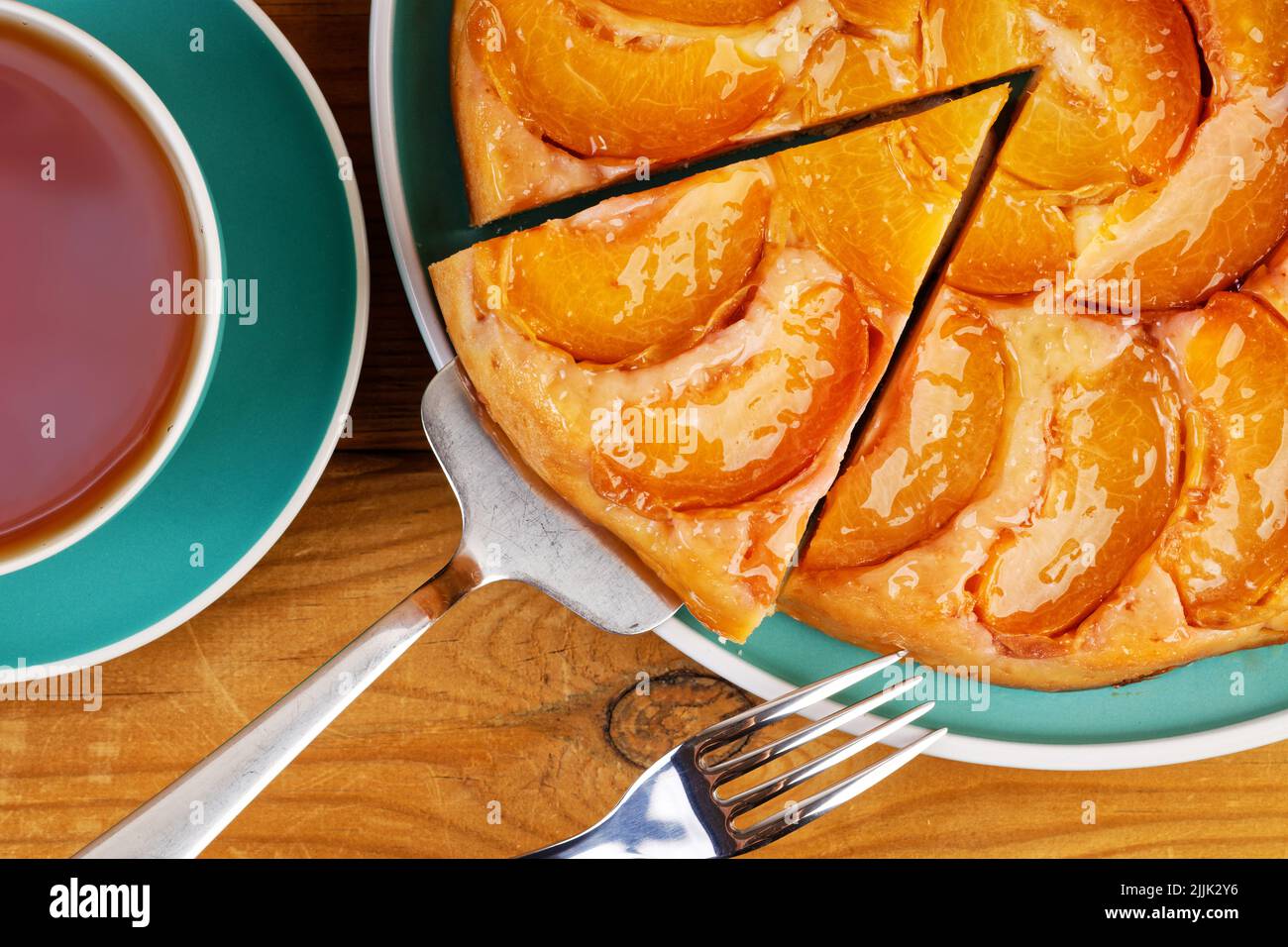 Gros plan tarte maison avec pêches et tasse de thé sur une table en bois. Vue de dessus. Banque D'Images Gros plan tarte maison avec pêches et tasse de thé sur une table en bois. Vue de dessus. Banque D'Images