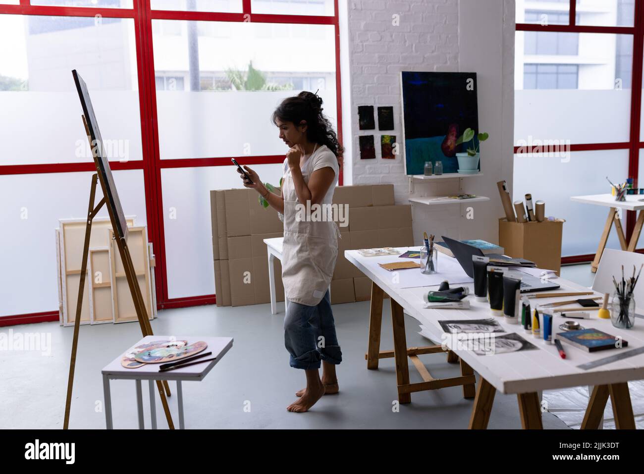 Image d'une artiste biraciale prenant une photo de nouveau tableau en studio Banque D'Images