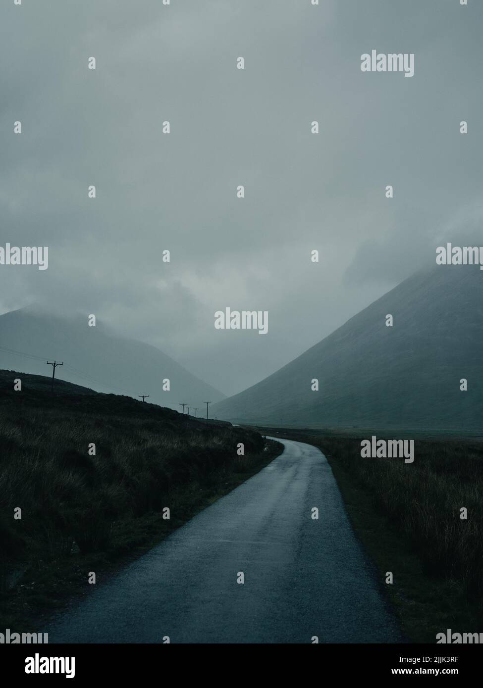 Nuages bas et pluie sur une route de montagne dans le paysage vide isolé de l'Écosse - paysage vide de route sombre - paysage de nuage de route Banque D'Images