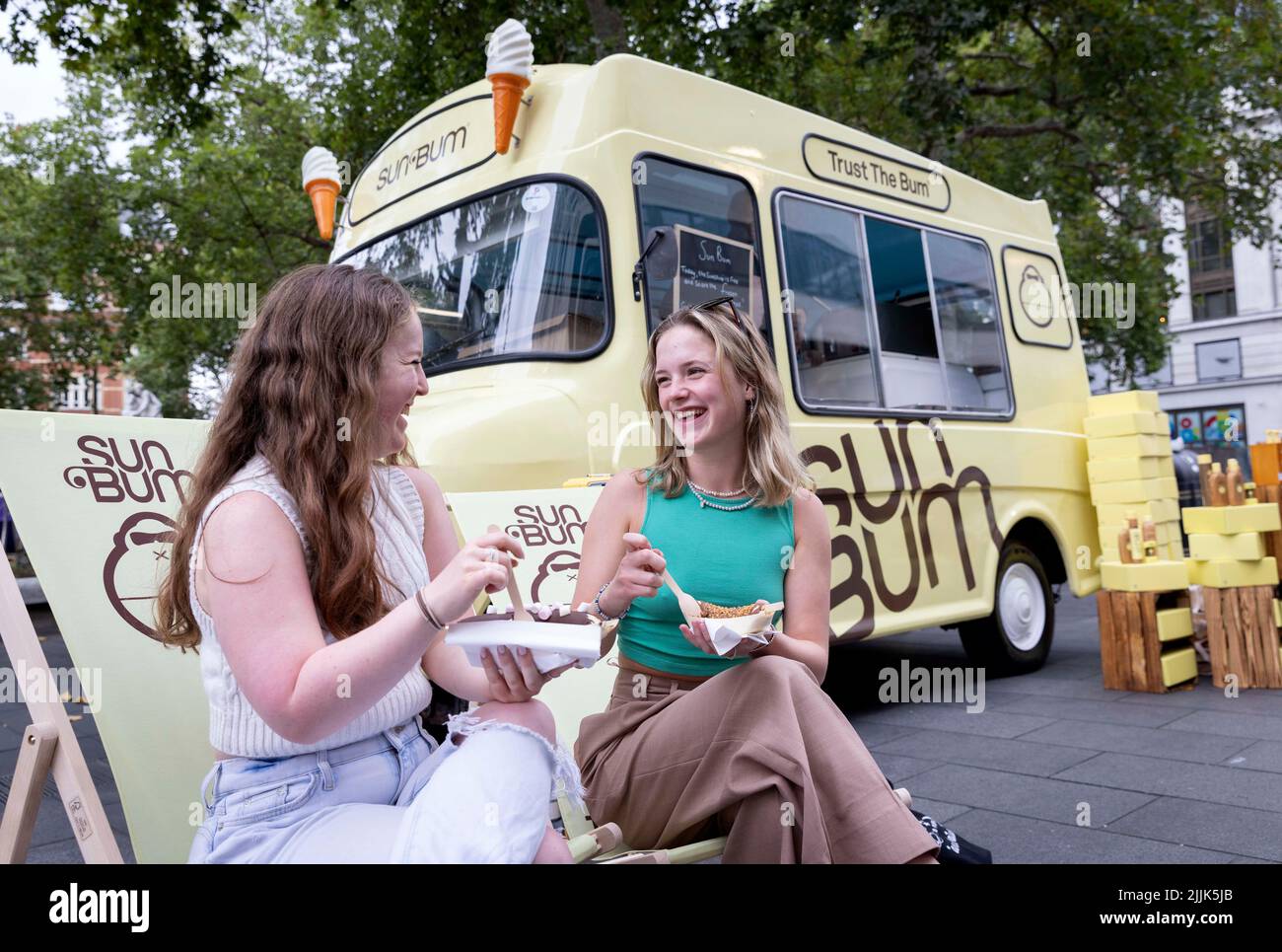 USAGE ÉDITORIAL UNIQUEMENT (de gauche à droite) Naomi Barker et Ellie visite somptueuse de Sun Bum's Food Truck, qui offre des bananes surgelées gratuites servies dans un style californien populaire, avec un choix de garnitures, Londres. Date de publication : mercredi 26 juillet 2022. Cette pop-up, créée par la marque bio Sun Bum, apparaît dans trois autres sites britanniques à Londres, Brighton et Broadescaliers cette semaine, pour souligner l'importance du port de SPF tout au long de l'année. Le crédit photo devrait se lire: Matt Alexander/PA fil Banque D'Images