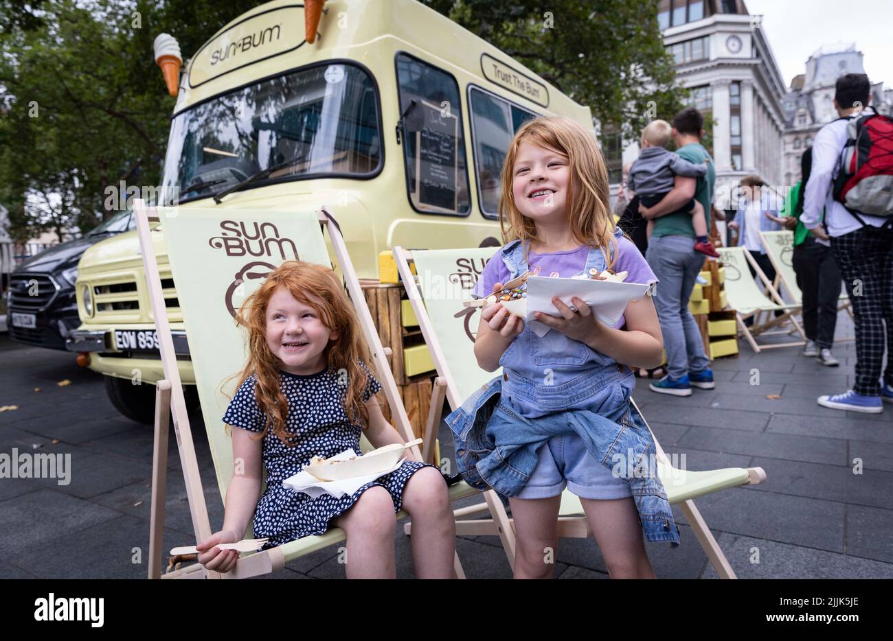 USAGE ÉDITORIAL UNIQUEMENT (de gauche à droite) Sienna, 5 ans, et Isla McKie, de Londres, visitent la fenêtre en relief du camion alimentaire de Sun Bum, qui offre gratuitement des bananes congelées servies dans un style californien populaire, avec un choix de garnitures, Londres. Date de publication : mercredi 26 juillet 2022. Cette pop-up, créée par la marque bio Sun Bum, apparaît dans trois autres sites britanniques à Londres, Brighton et Broadescaliers cette semaine, pour souligner l'importance du port de SPF tout au long de l'année. Le crédit photo devrait se lire: Matt Alexander/PA fil Banque D'Images