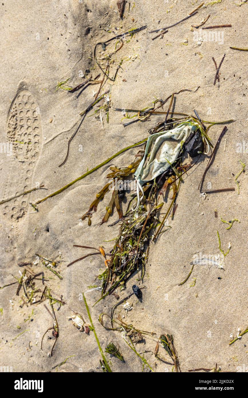 Un masque médical utilisé sur la plage Banque D'Images