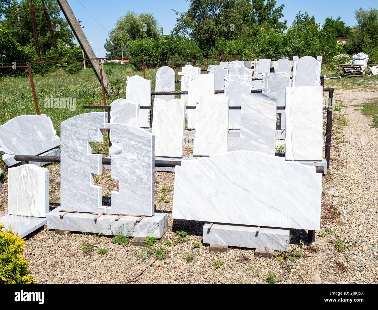 pierres vierges graviers et dalles de tombe dans l'atelier de granit rural extérieur le jour ensoleillé d'été Banque D'Images
