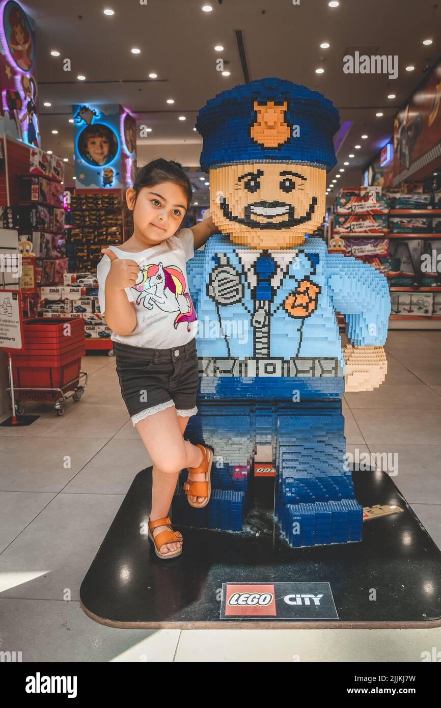 Une petite fille douce avec un héros Lego dans une boutique de jouets, Istanbul, Turquie Banque D'Images