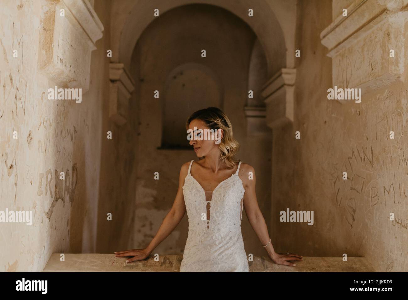 Une mariée du Moyen-Orient posant pour une séance photo dans le fond d'une ancienne arche. Banque D'Images