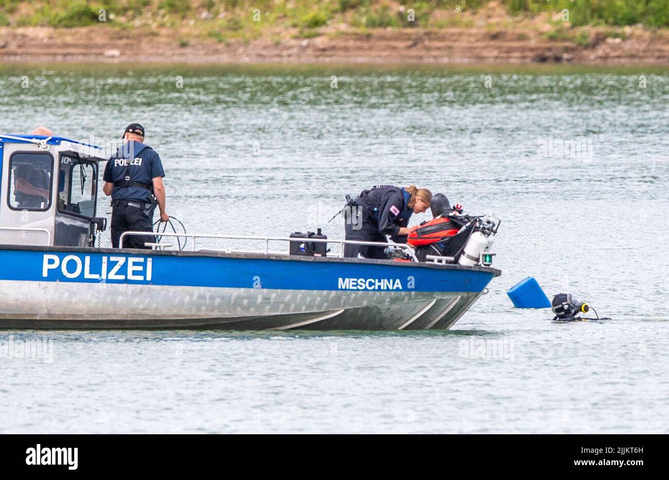 Porta Westfalica, Allemagne. 27th juillet 2022. Un bateau de police avec des plongeurs de l'unité de plongée de Bochum est amarré à un endroit marqué et floqué par un sondeur sur un étang de gravier où deux personnes n'ont pas pu se trouver à la surface pour des raisons inexpliquées lors de la baignade le dimanche (24.07.2022). Selon un porte-parole du service des incendies, certaines parties du lac ont environ 30 mètres de profondeur. Les experts de la police veulent maintenant chercher les deux personnes avec une sonde sous-marine. Crédit : Lino Mirgeler/dpa/Alay Live News Banque D'Images