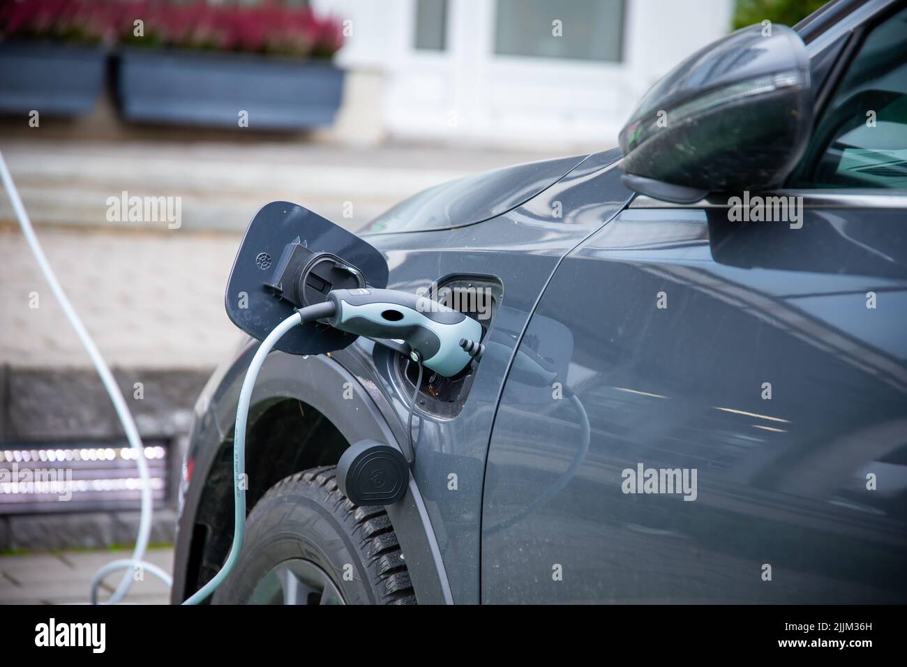Un gros plan du câble de chargement de voiture électrique branché. Banque D'Images