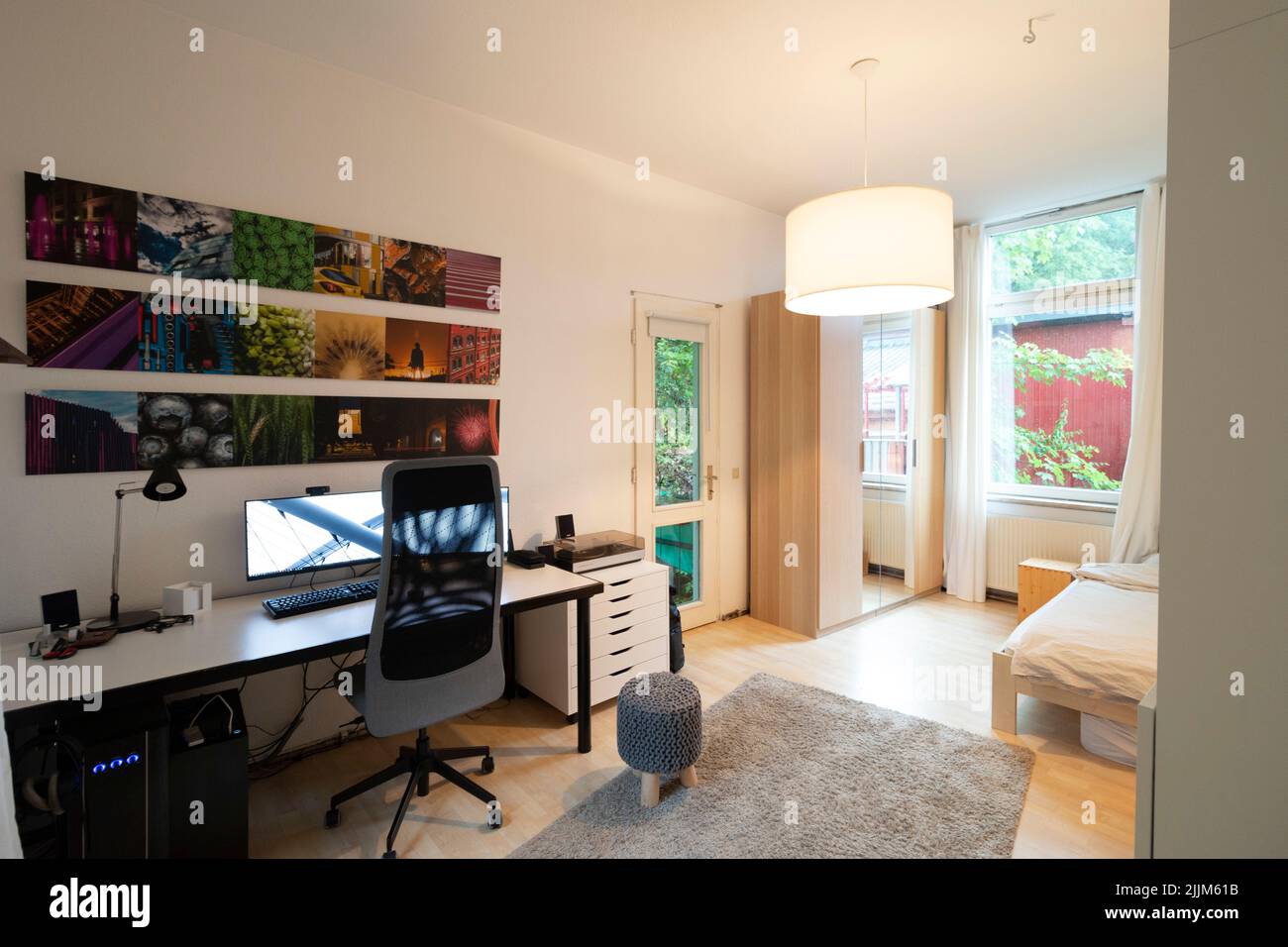 Vue intérieure d'une chambre d'un étudiant avec un bureau, un ordinateur et des photos aux couleurs assorties Banque D'Images