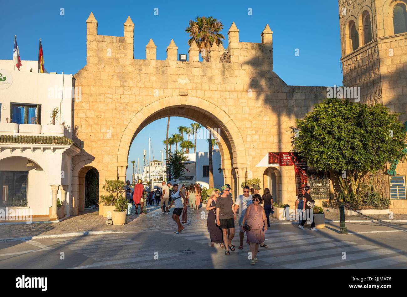 Les touristes marchent à côté d'une porte d'entrée de la marina à Port El Kantaoui en Tunisie. Banque D'Images