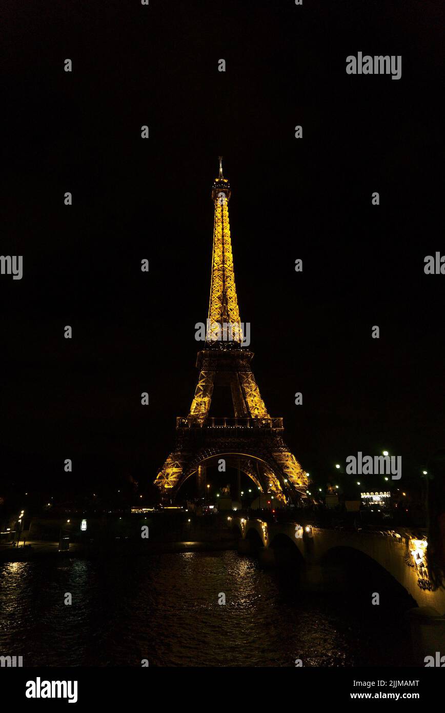 Un cliché vertical de la tour Eiffel la nuit avec des lumières à Paris, en France Banque D'Images