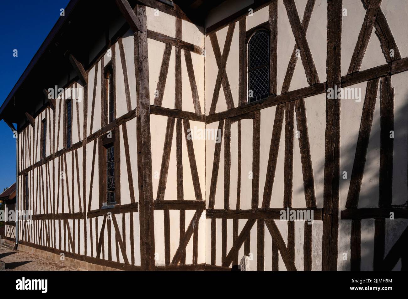 Des bois de chêne anciens, certains joints en croix de St Andrew, divisent les murs hauts de l'église notre-Dame à colombages de Châtillon-sur-Broué dans la campagne du pays du Der de la Marne, dans le Grand est, en France. L'église, construite au début de 1500s, possède une véranda inhabituelle entièrement fermée et est parmi les attractions lors d'une visite balisée des églises, chapelles et bâtiments domestiques à pans de bois de la région historique de Champagne. Banque D'Images