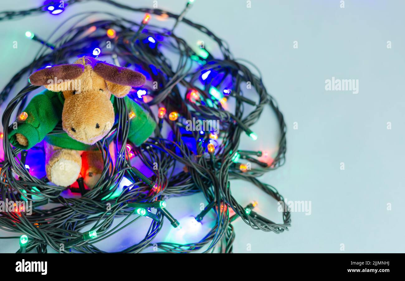 Une vue de dessus de l'ornement de cerf de Noël sur une série de lumières colorées sur une table blanche avec un arrière-plan flou Banque D'Images