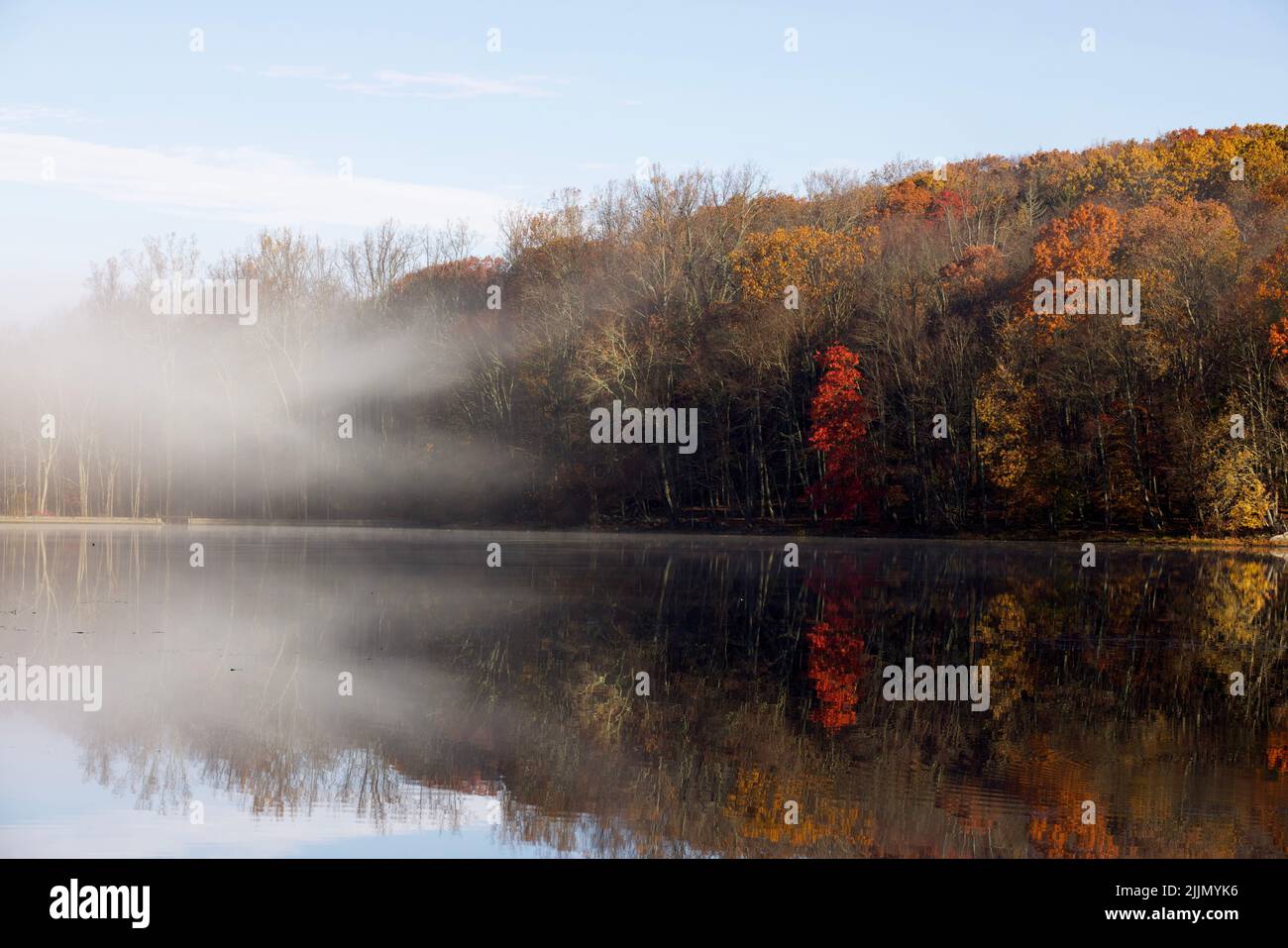 Une vue magnifique sur les collines verdoyantes qui se réfléchit sur le lac Teatown avec de la fumée dans l'État de New York Banque D'Images