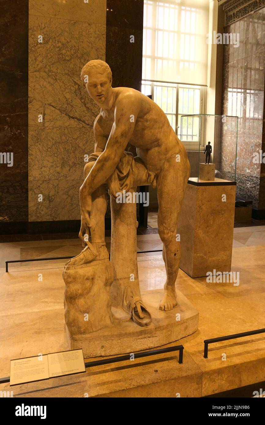 La sculpture d'Hermes fixant sa Sandale au musée du Louvre à Paris, France  Photo Stock - Alamy