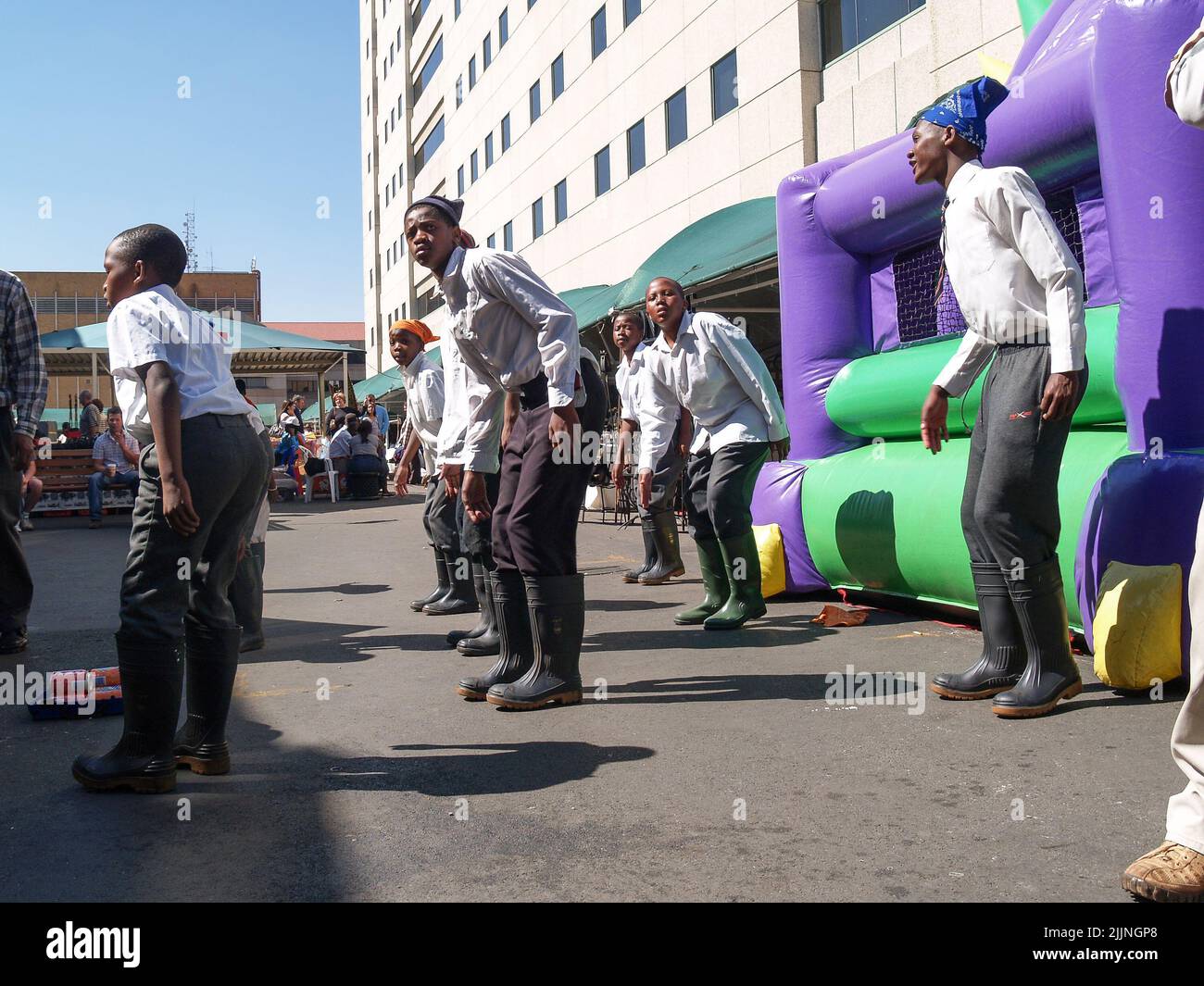 Johannesburg Afrique du Sud - 12 août 2027; des hommes africains dansant dans la rue en bottes de gomboots pour les touristes passant Banque D'Images