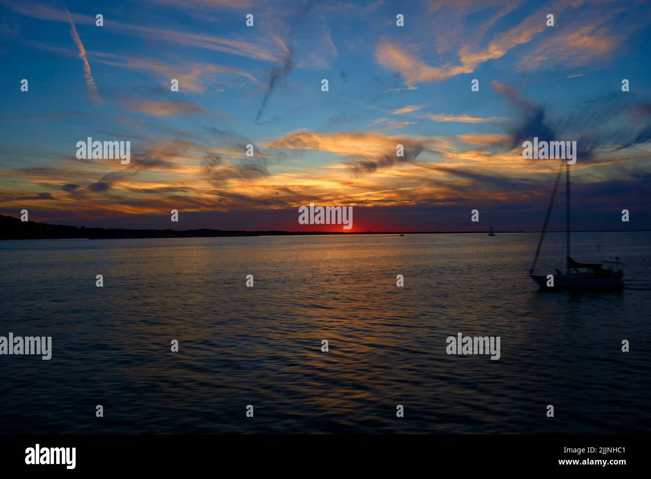 Une belle photo d'un voilier dans l'océan avec le coucher du soleil sur le fond Banque D'Images