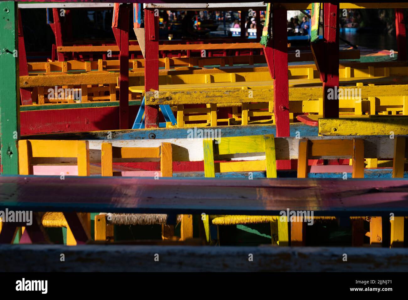 Des chaises jaunes distinctives des bateaux de la trajinera le voyage les canaux de Xochimilco dans la ville de Mexico. Banque D'Images