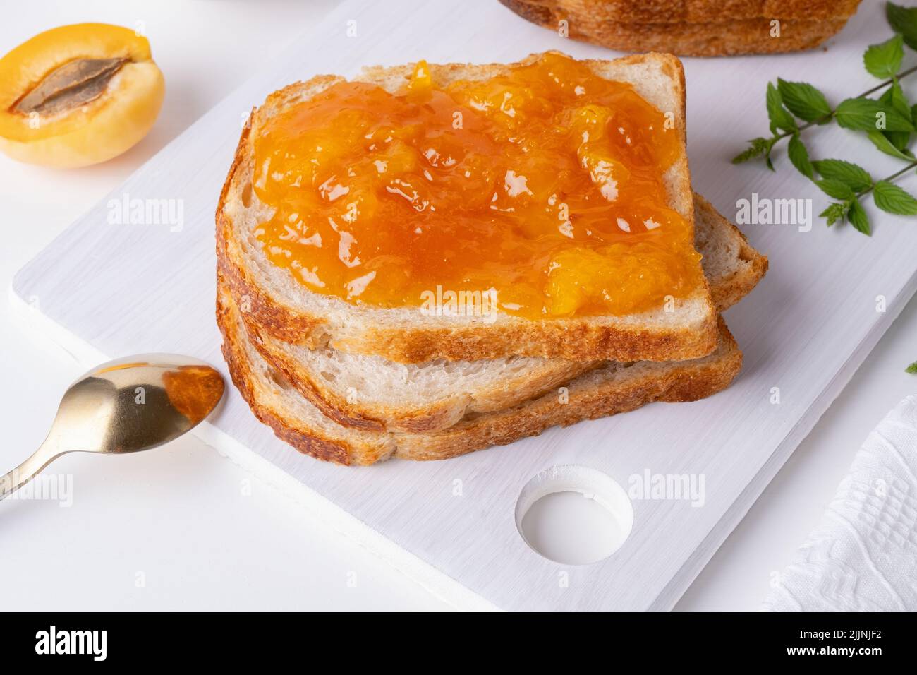 Toasts de pain à la confiture d'abricot et fruits frais à la menthe Banque D'Images