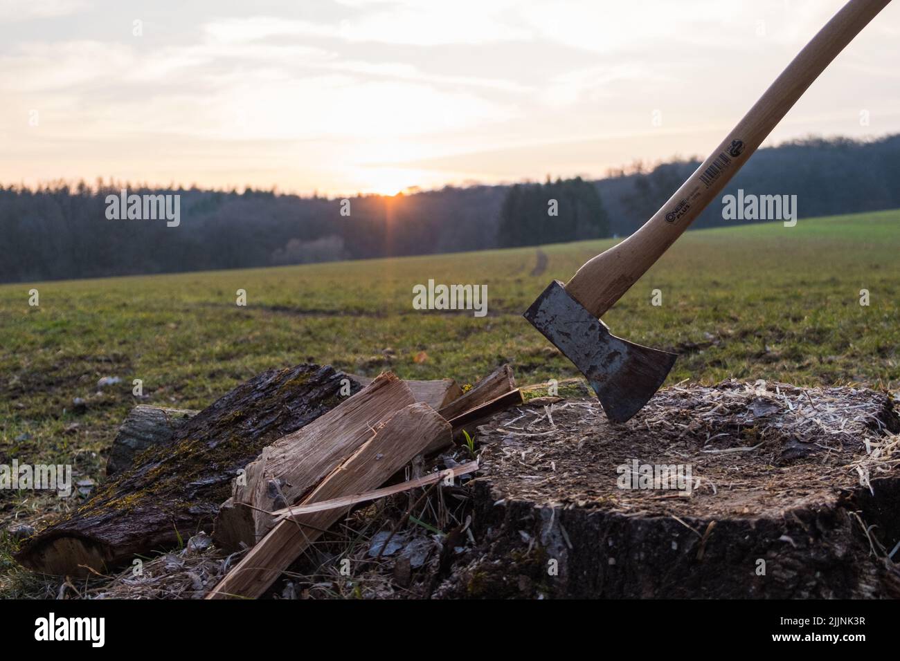 Une hache pour fendre le bois au coucher du soleil Banque D'Images