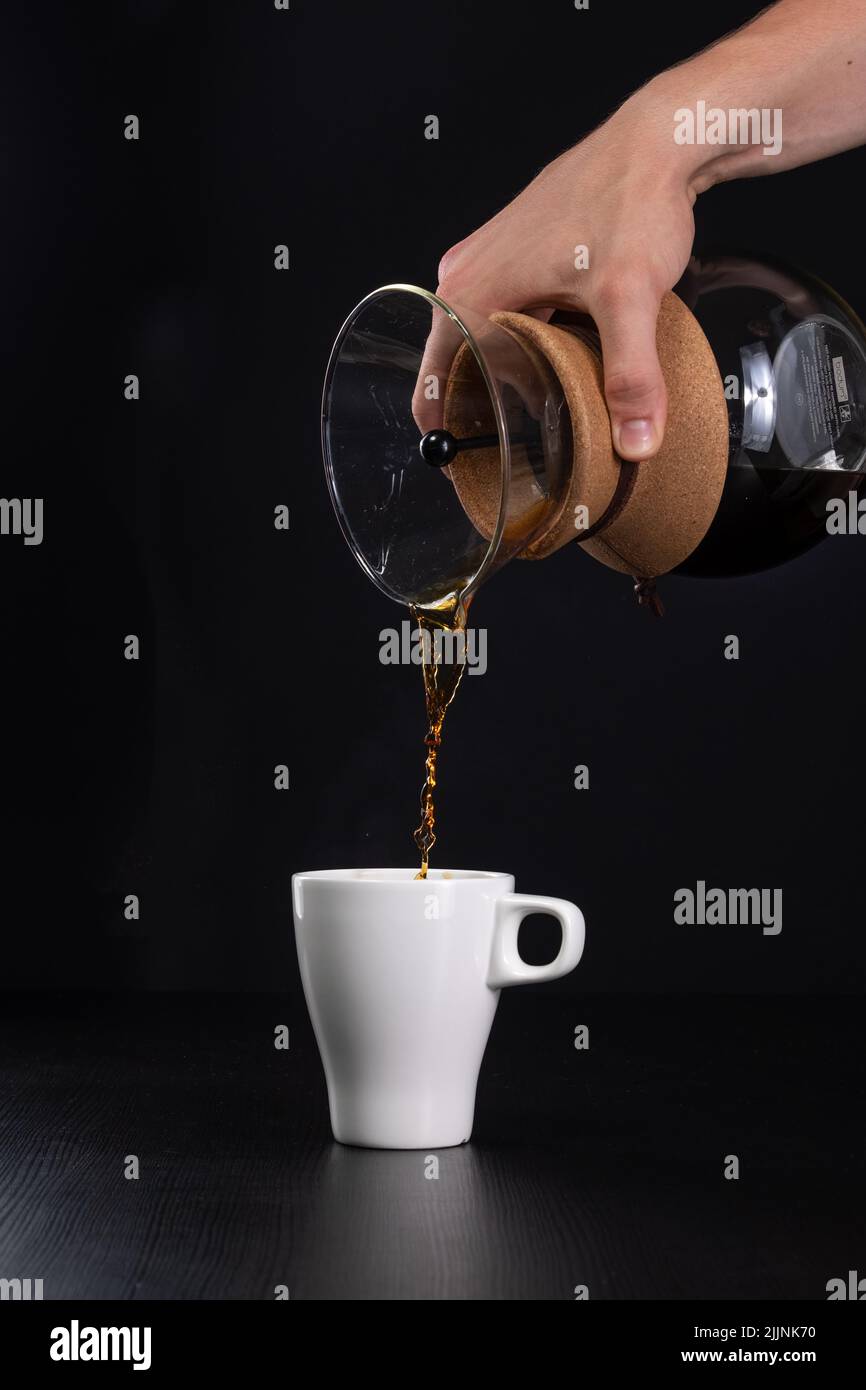 Une dose verticale de café versé dans une cafetière en verre Banque D'Images