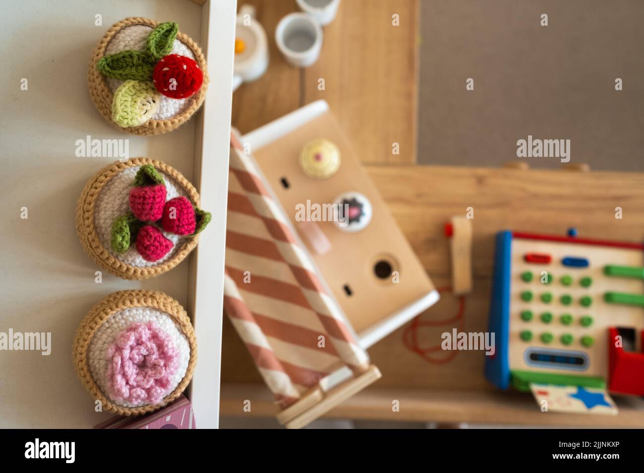 Nourriture artificielle dans la cuisine des enfants. Sur l'étagère sont les légumes et les fruits faits de fils tricotés. Banque D'Images