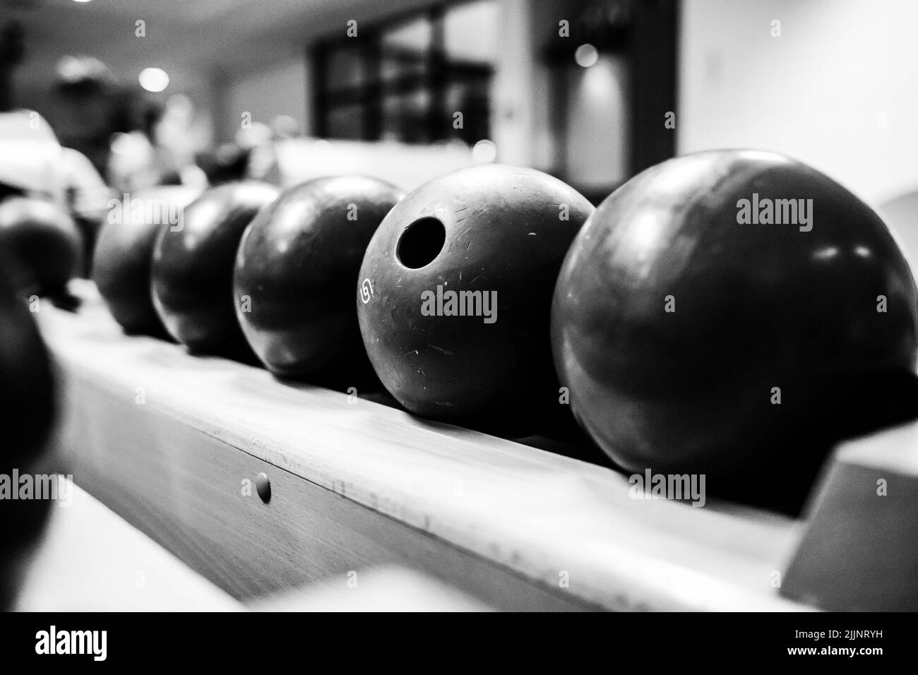 Un gros plan en niveaux de gris de boules de bowling sur l'aire de jeux Banque D'Images