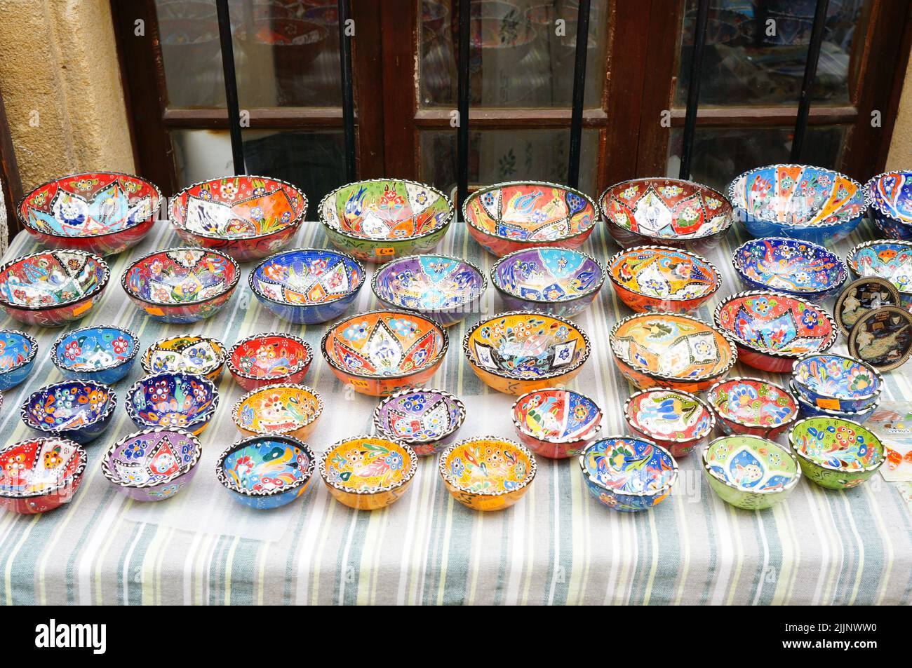 Un mélange de bols colorés avec des motifs à vendre sur une table par une boutique de cadeaux Banque D'Images
