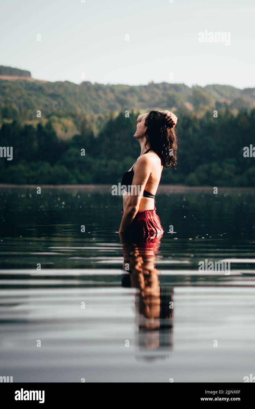une photo de femme debout dans l'eau, au bord du lac Banque D'Images
