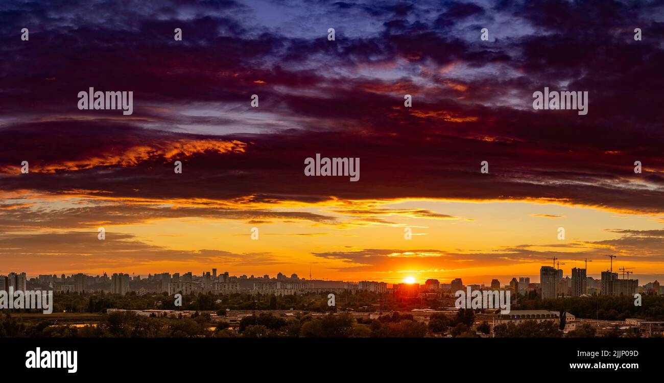 Vue panoramique incroyable de la silhouette de la grande ville en soirée sur fond de nuages incroyablement lumineux et multicolores au coucher du soleil. Kiev Banque D'Images