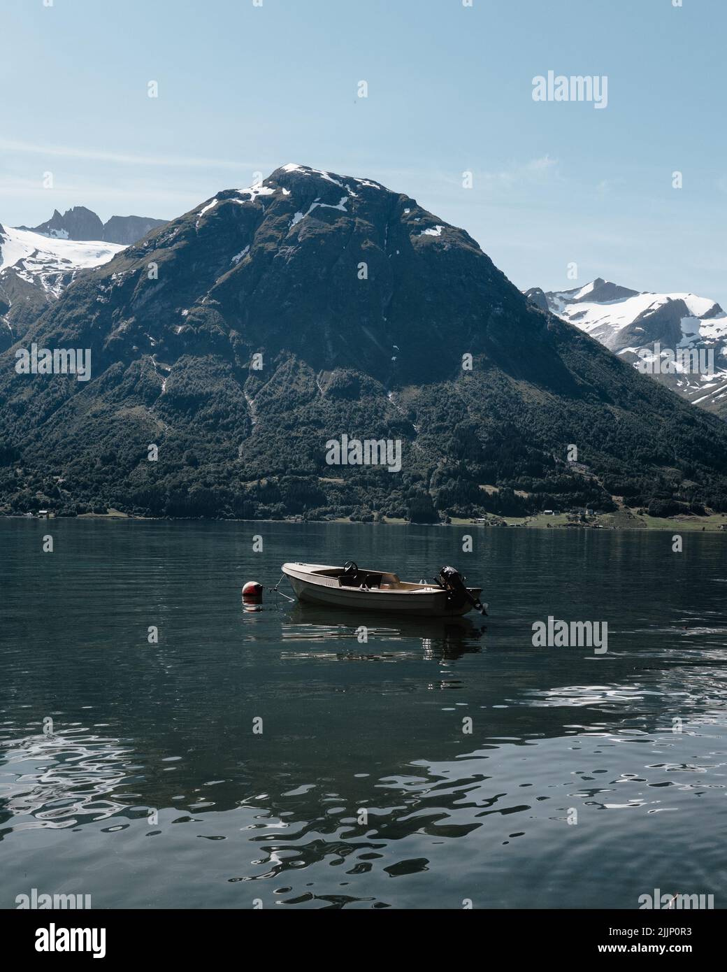 plan vertical d'un bateau dans le lac sur le fond d'une grande montagne enneigée Banque D'Images