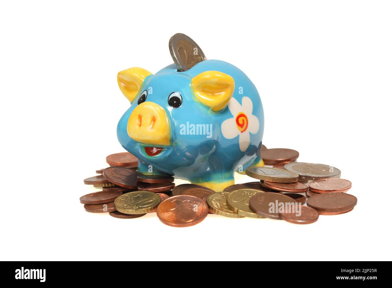 Une tirelire bleue avec une pièce d'euro, sur un tas de pièces, isolée sur un fond blanc Banque D'Images