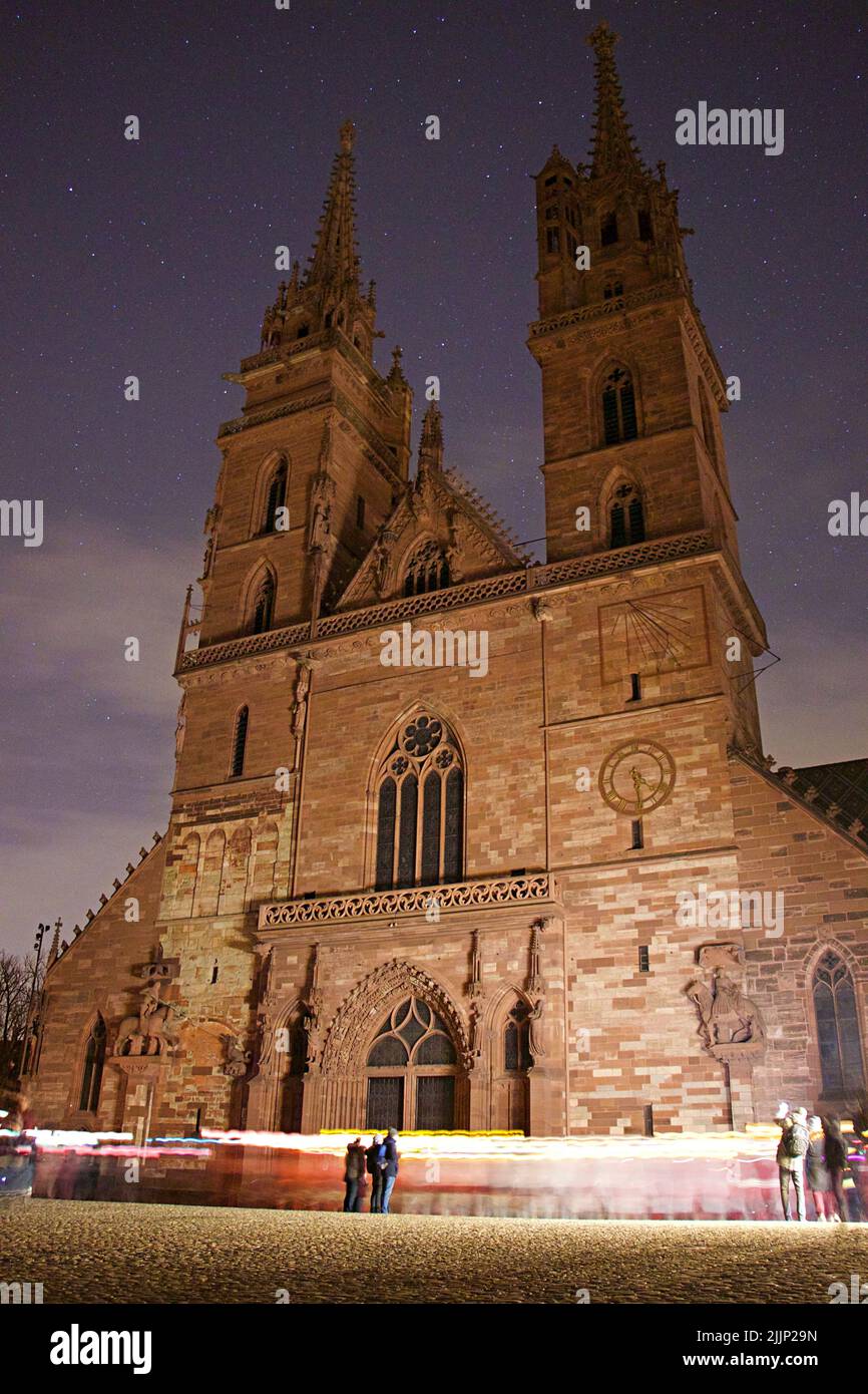 Une vue verticale des personnes qui prennent des photos de la cathédrale de Bâle Minster à Bâle, en Suisse, sur un fond de ciel étoilé Banque D'Images