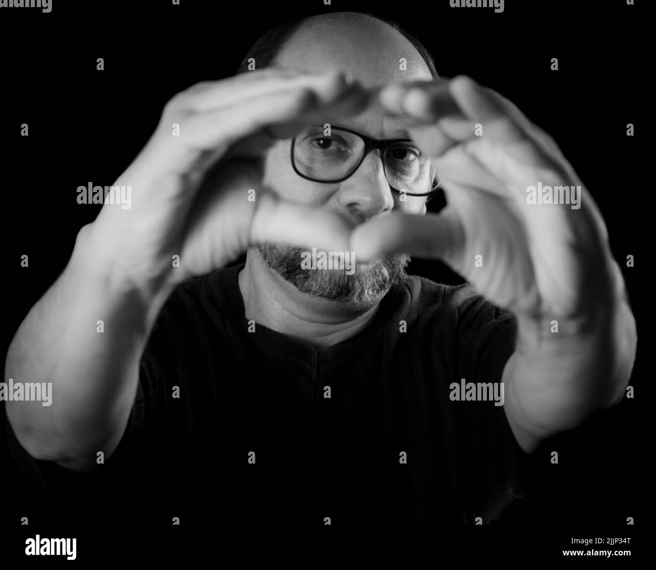 Portrait en niveaux de gris d'un homme barbu portant des lunettes contre un fond noir, Salvador, Bahia, Brésil Banque D'Images