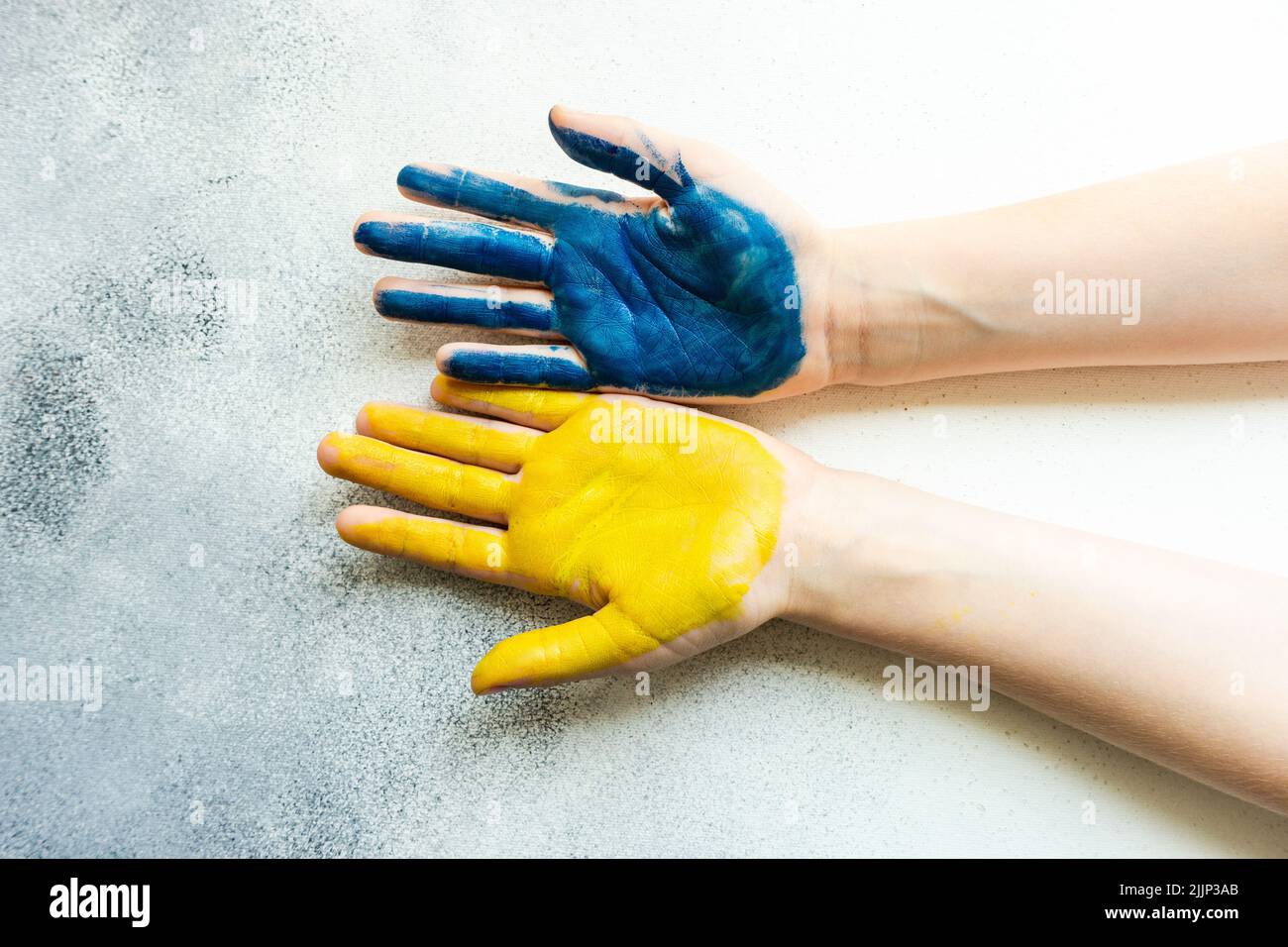 Gros plan des mains d'une personne peintes en jaune et bleu pour symboliser le soutien de l'Ukraine Banque D'Images