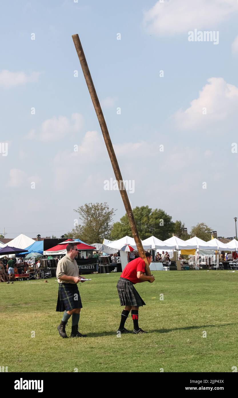 Sept 2010 Tulsa USA l'homme au kilt se prépare à lancer caber à Scots Fest alors que le juge avec le presse-papiers se tient derrière lui Banque D'Images