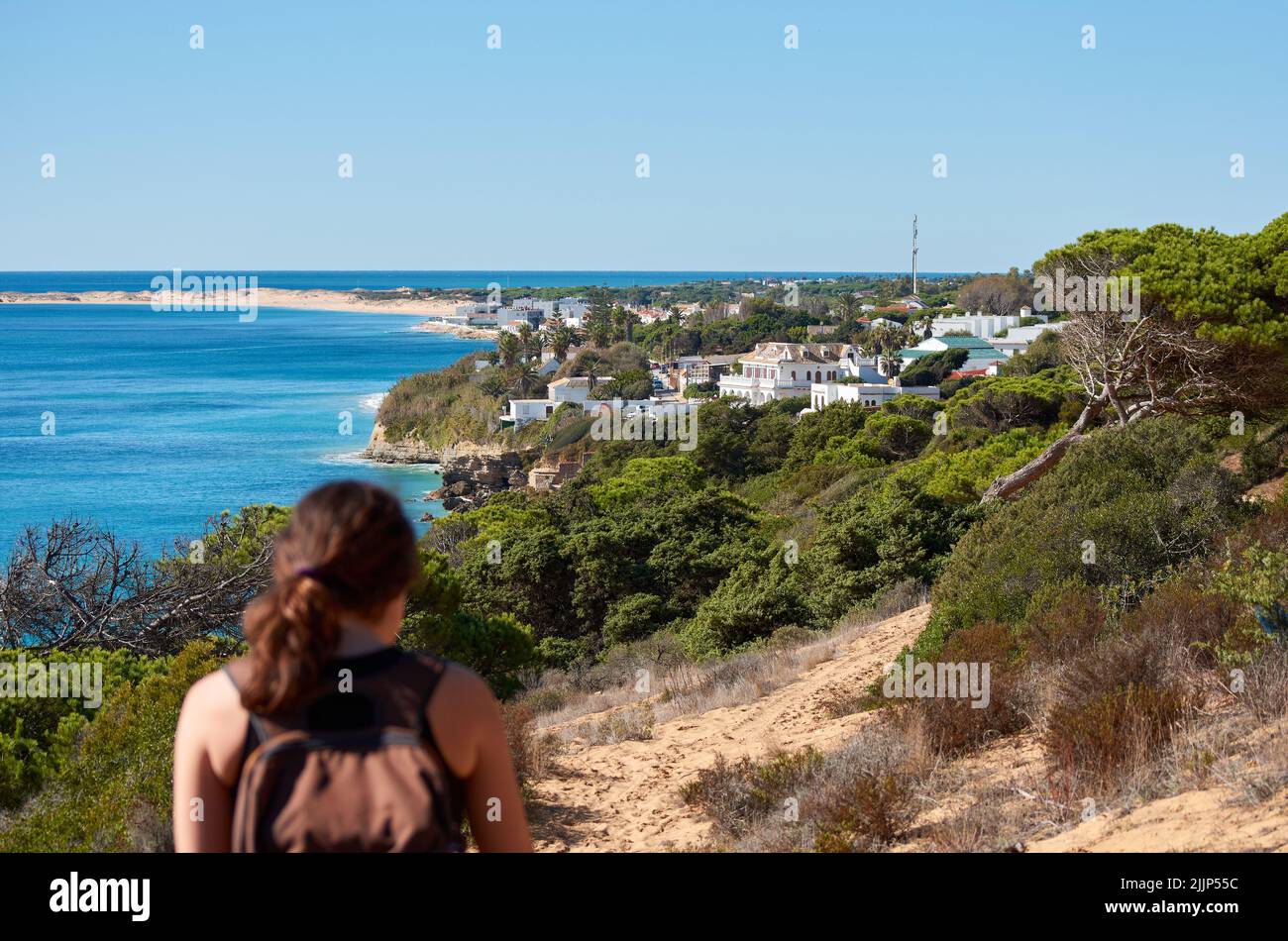Une vue arrière d'une randonneur aventureuse randonnée sur la colline de sable sur la côte Banque D'Images