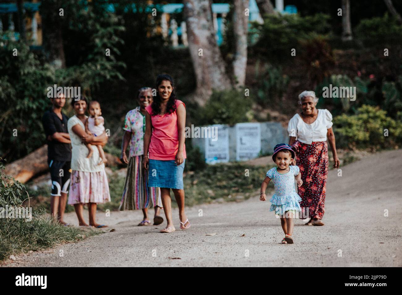 Une femme avec des enfants marchant le long d'une route de campagne et souriant Banque D'Images