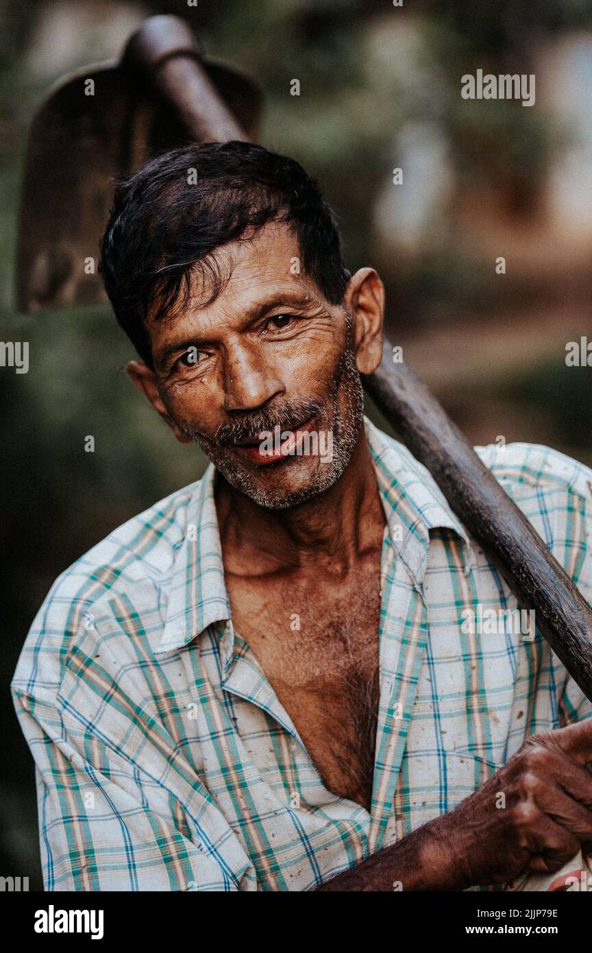 Une photo d'un homme tenant une pelle et souriant malheureusement Banque D'Images