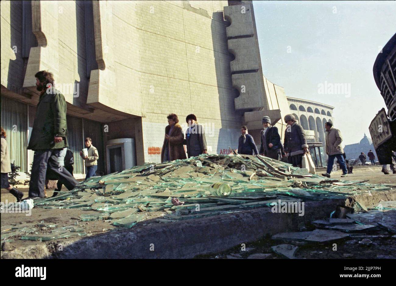 Bucarest, Roumanie, janvier 1989. Les gens passent par des brisures de verre et de débris sur la place de l'université, à côté de l'hôtel Intercontinental, quelques jours après la révolution anticommuniste de décembre 1989. Banque D'Images