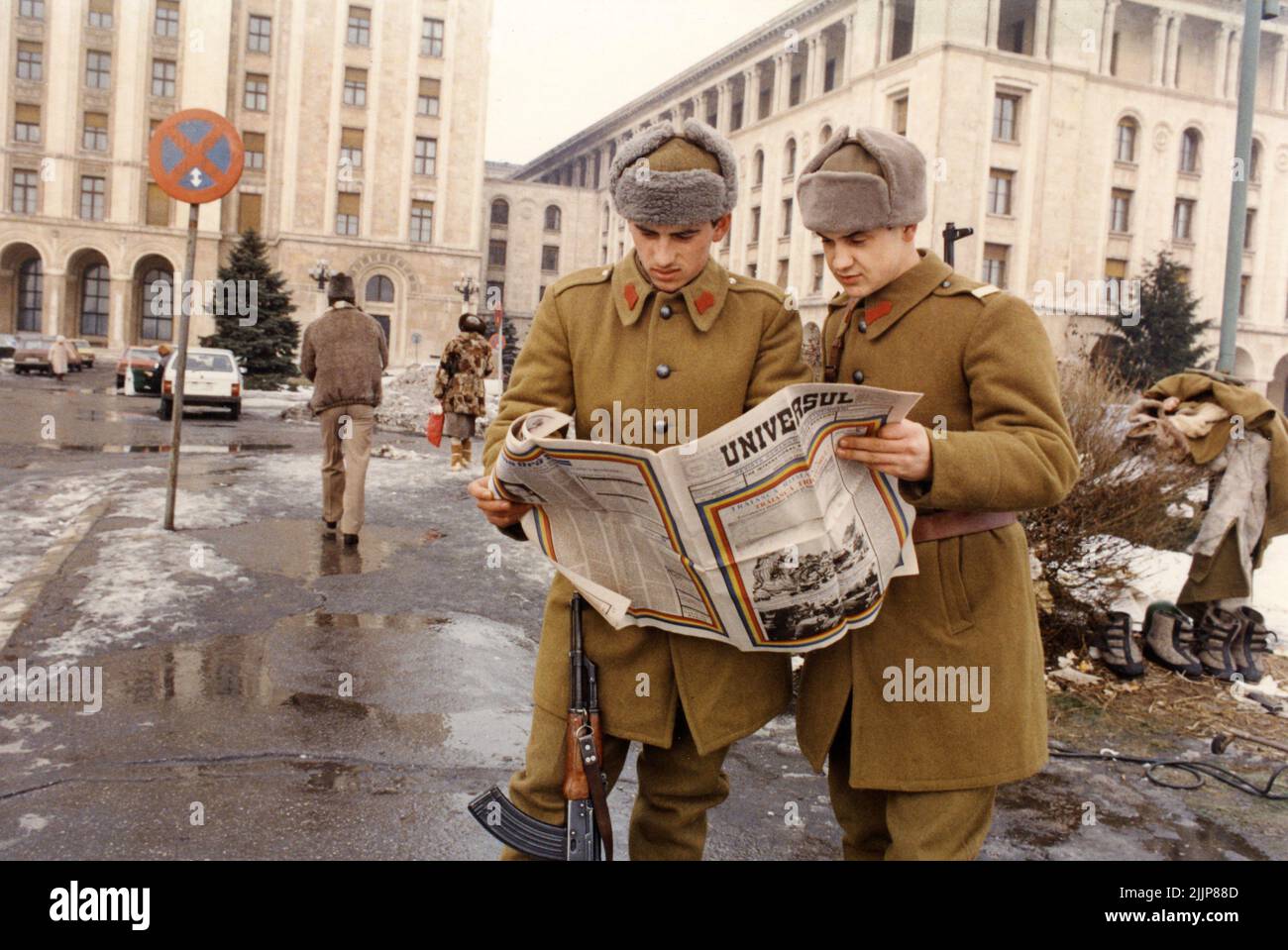 Bucarest, Roumanie, janvier 1990. Quelques jours après la Révolution roumaine, des soldats en face de 'Casa Scanteii/ Casa Presei Libere' regardant le magazine 'Universul'. 'Universul' a été publié aux Etats-Unis par A. Buhoiu pour les Roumains aux Etats-Unis il y avait une soif d'information en Roumanie, en particulier pour celui venant de l'extérieur du pays. Banque D'Images