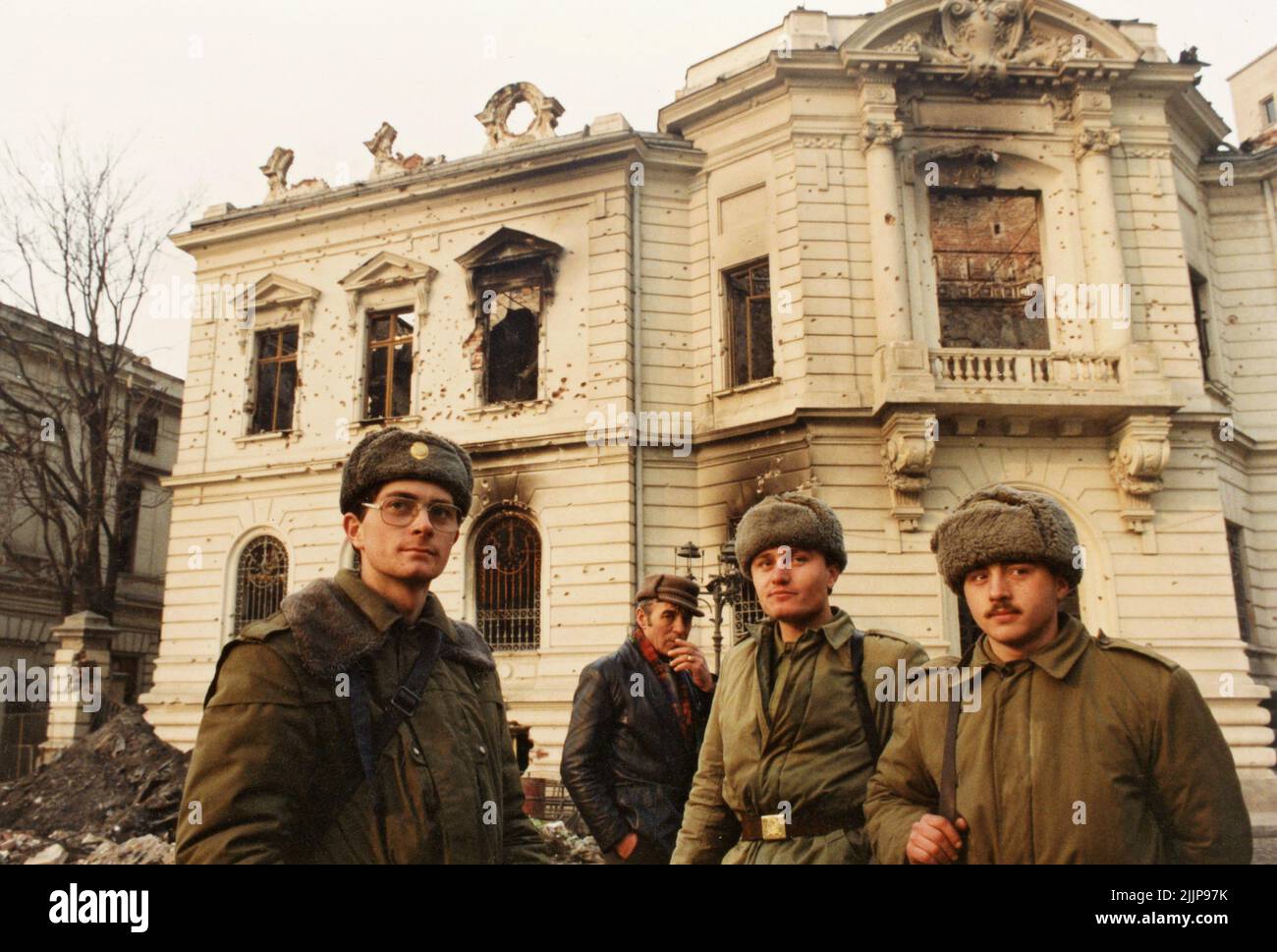 Bucarest, Roumanie, janvier 1990. Soldats à Piata Palatului/ Piata Revolutiei, devant un bâtiment historique détruit par les coups de feu lors de la révolution anticommuniste roumaine de décembre 1989. Banque D'Images