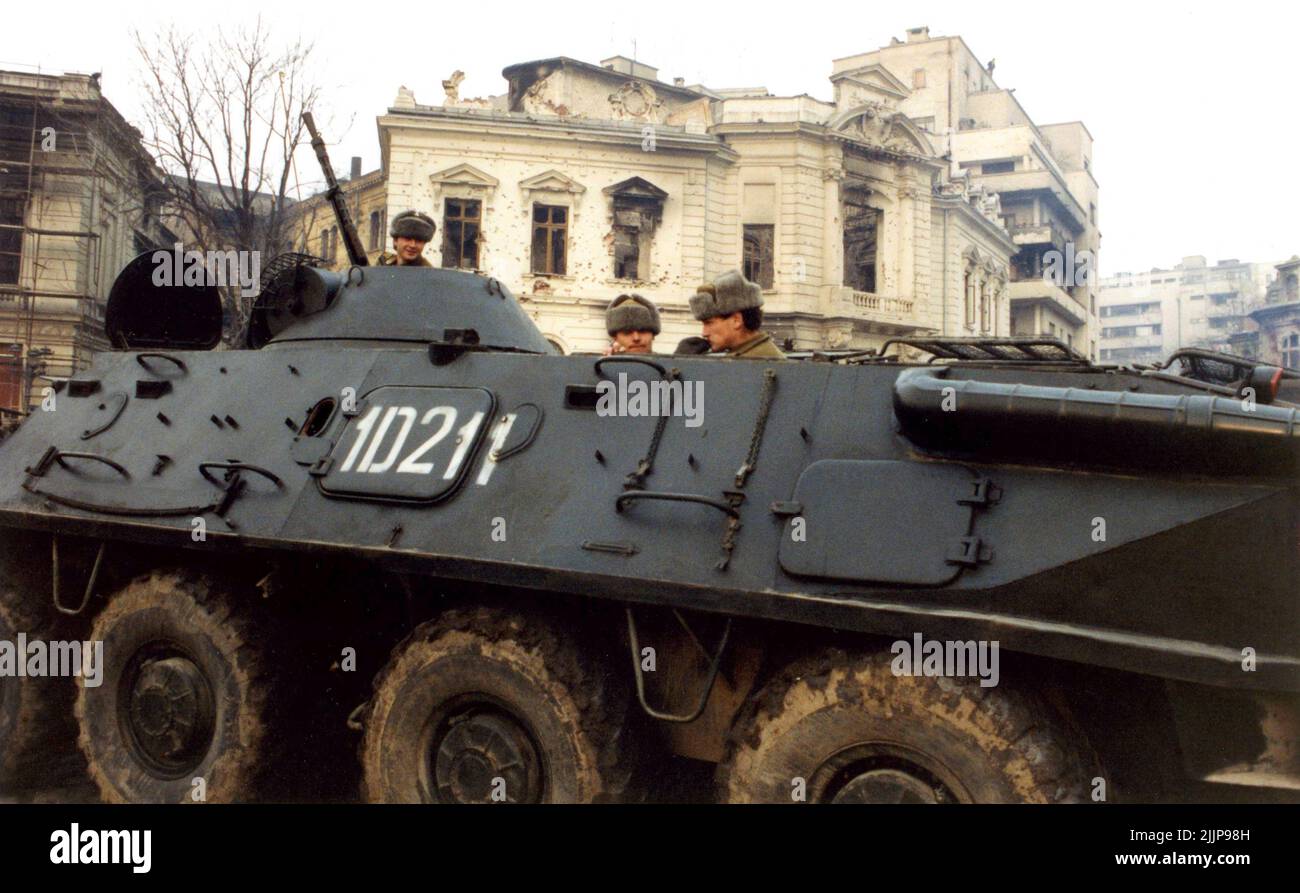 Bucarest, Roumanie, janvier 1990. Armée à Piata Palatului/ Piata Revolutiei, devant un bâtiment historique détruit par les coups de feu lors de la révolution anticommuniste roumaine de décembre 1989. Banque D'Images