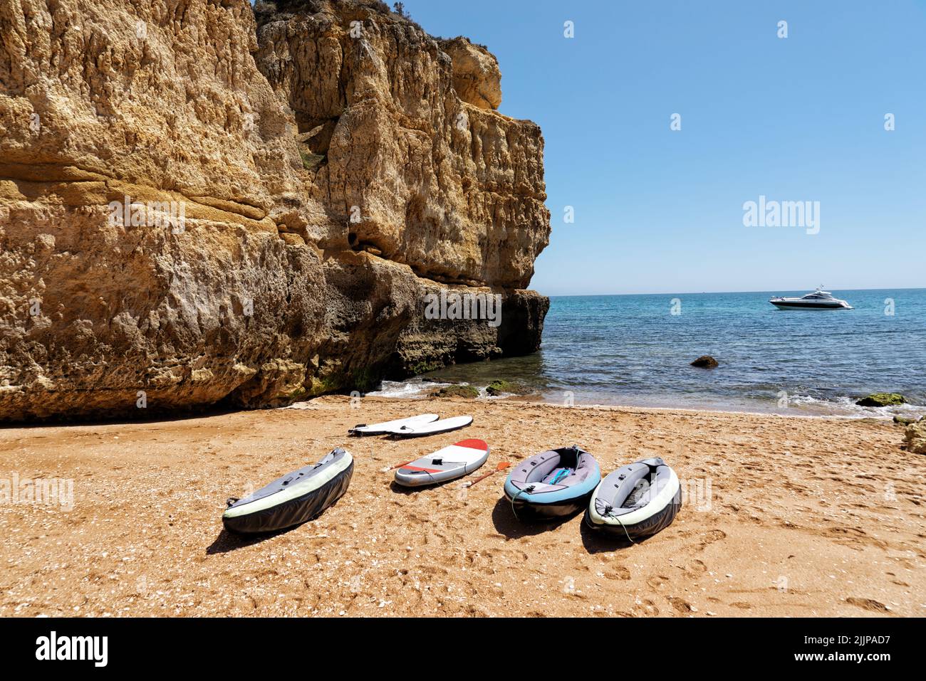 Une vue sur les bateaux gonflables sur le rivage d'une mer ou d'un océan près d'une énorme falaise lors d'une chaude journée d'été Banque D'Images