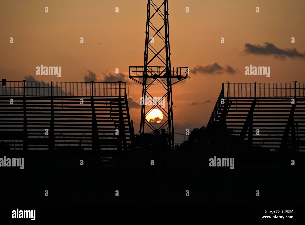 Une belle vue sur une tour silhouetée avec bâtiment contre un ciel orangé de coucher de soleil Banque D'Images