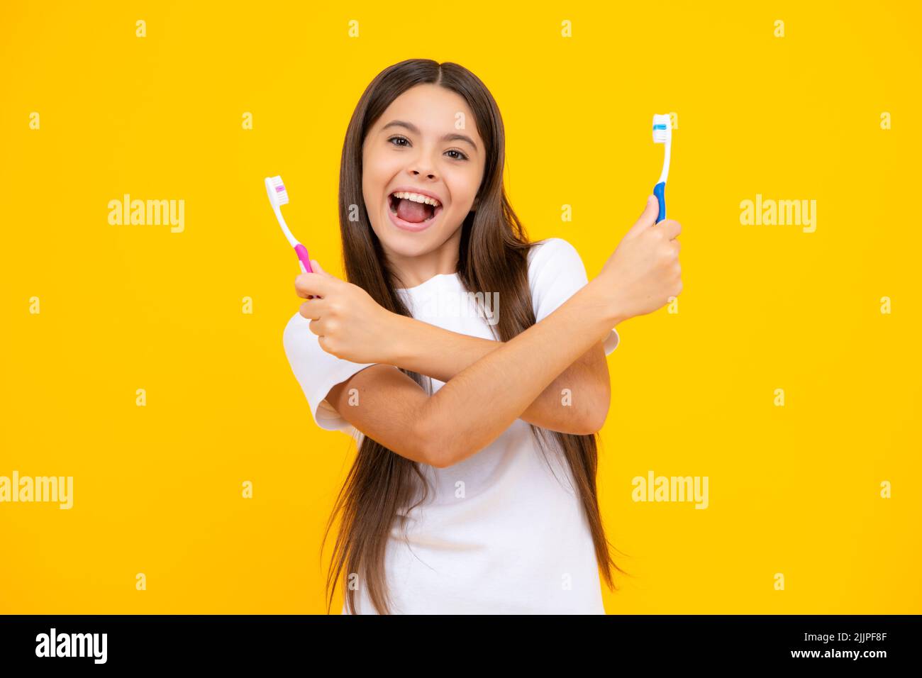 Portrait de la jeune fille caucasienne tient une brosse à dents se brossant ses dents, routine du matin, hygiène dentaire, isolé sur fond jaune. Excitée Banque D'Images