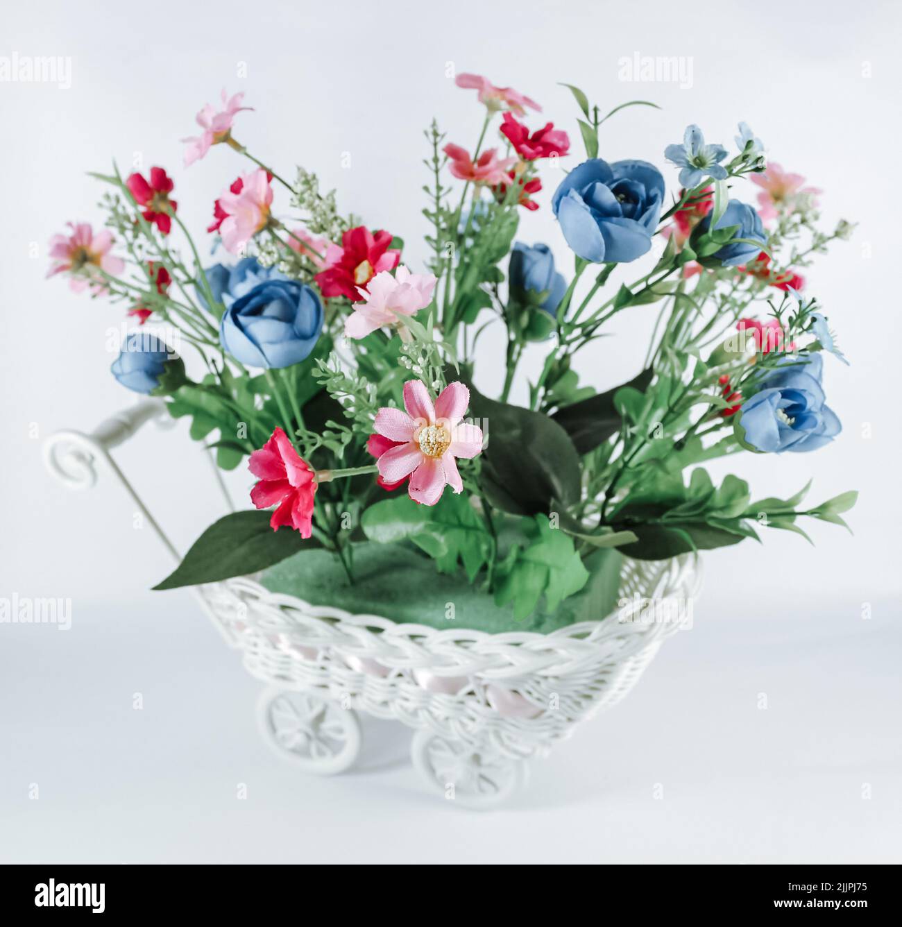 Un gros plan du bouquet de fleurs artificielles isolées sur fond blanc. Banque D'Images