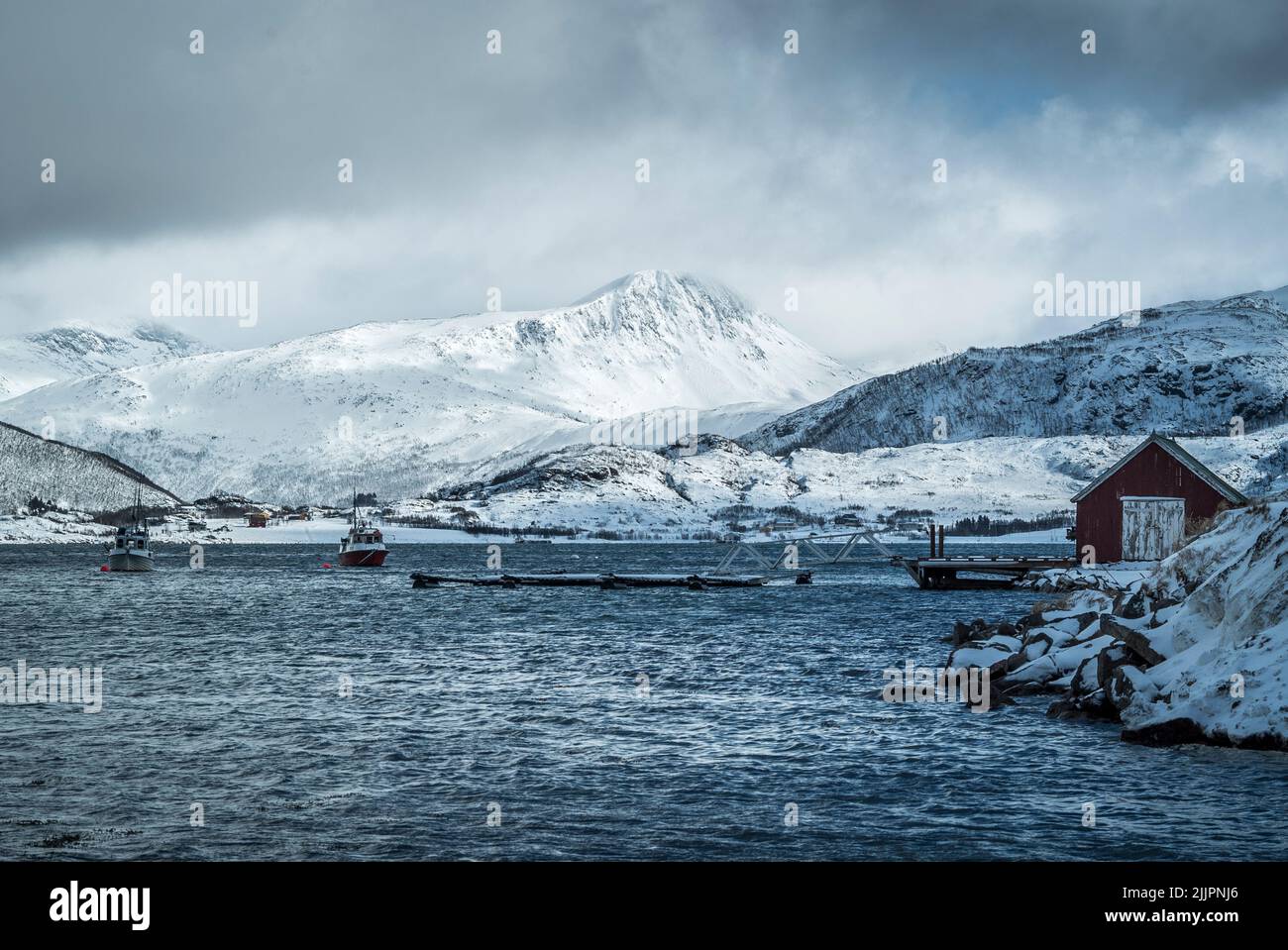 Une belle photo de l'île de Kvaloya, en Norvège, en hiver avec un quai, et une cabine en arrière-plan Banque D'Images