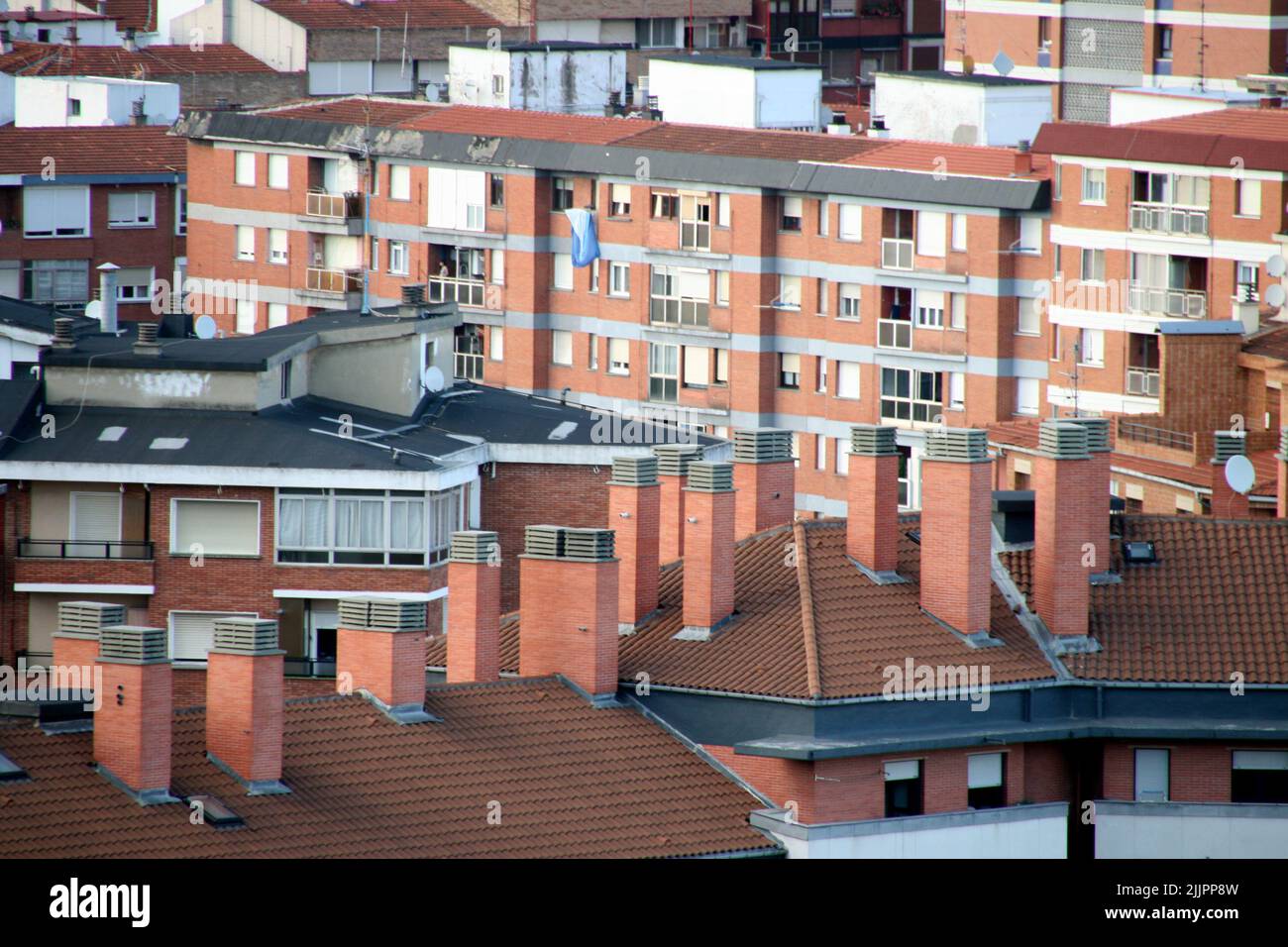 Le toit rouge et carrelé d'un bâtiment blanc avec cheminées, Bilbao, Espagne Banque D'Images